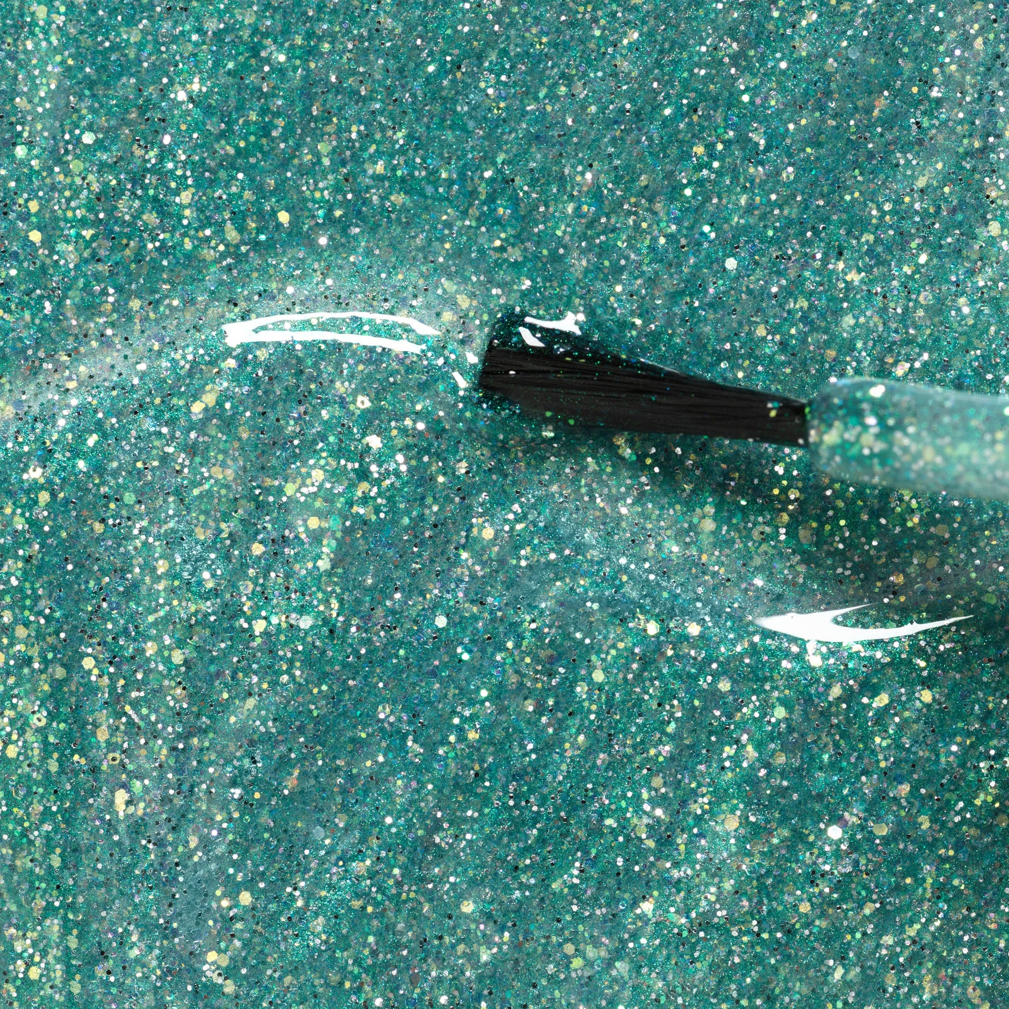 Close-up of a teal glittery surface with a black applicator