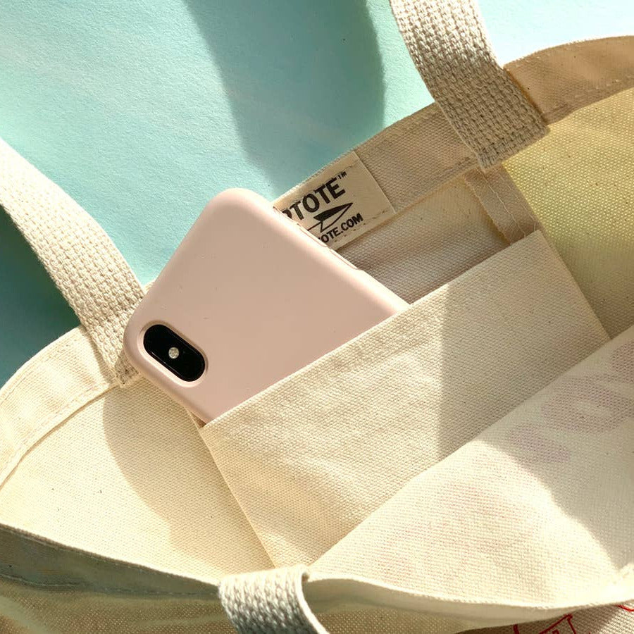 Pink phone case in a beige tote bag with a visible brand label.