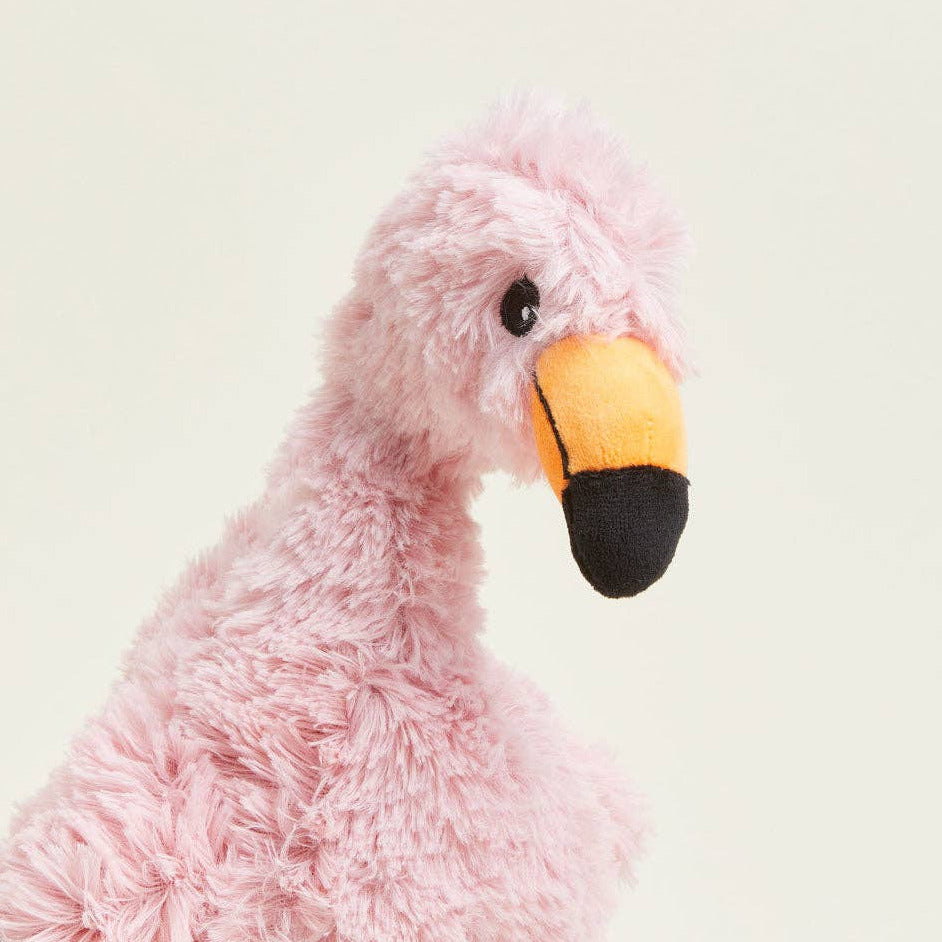 Pink plush flamingo toy on a light gray background