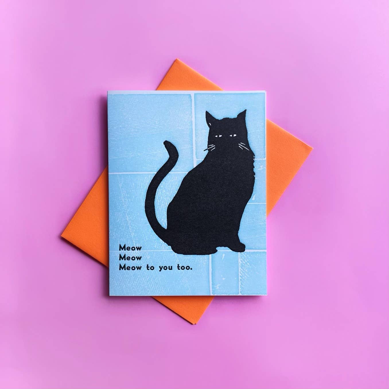 Card with black cat illustration and text on a pink background