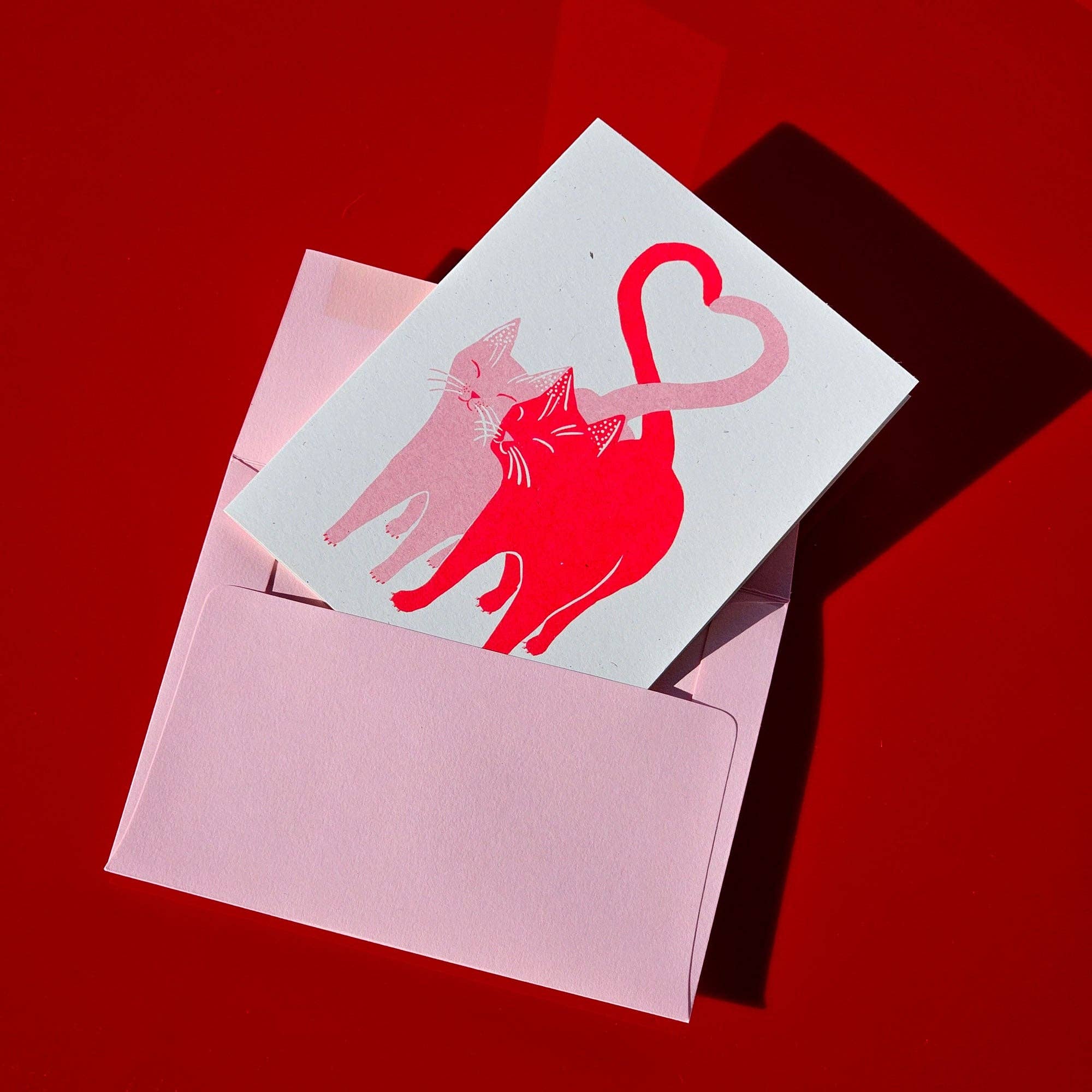 Card with pink cat design on a red background