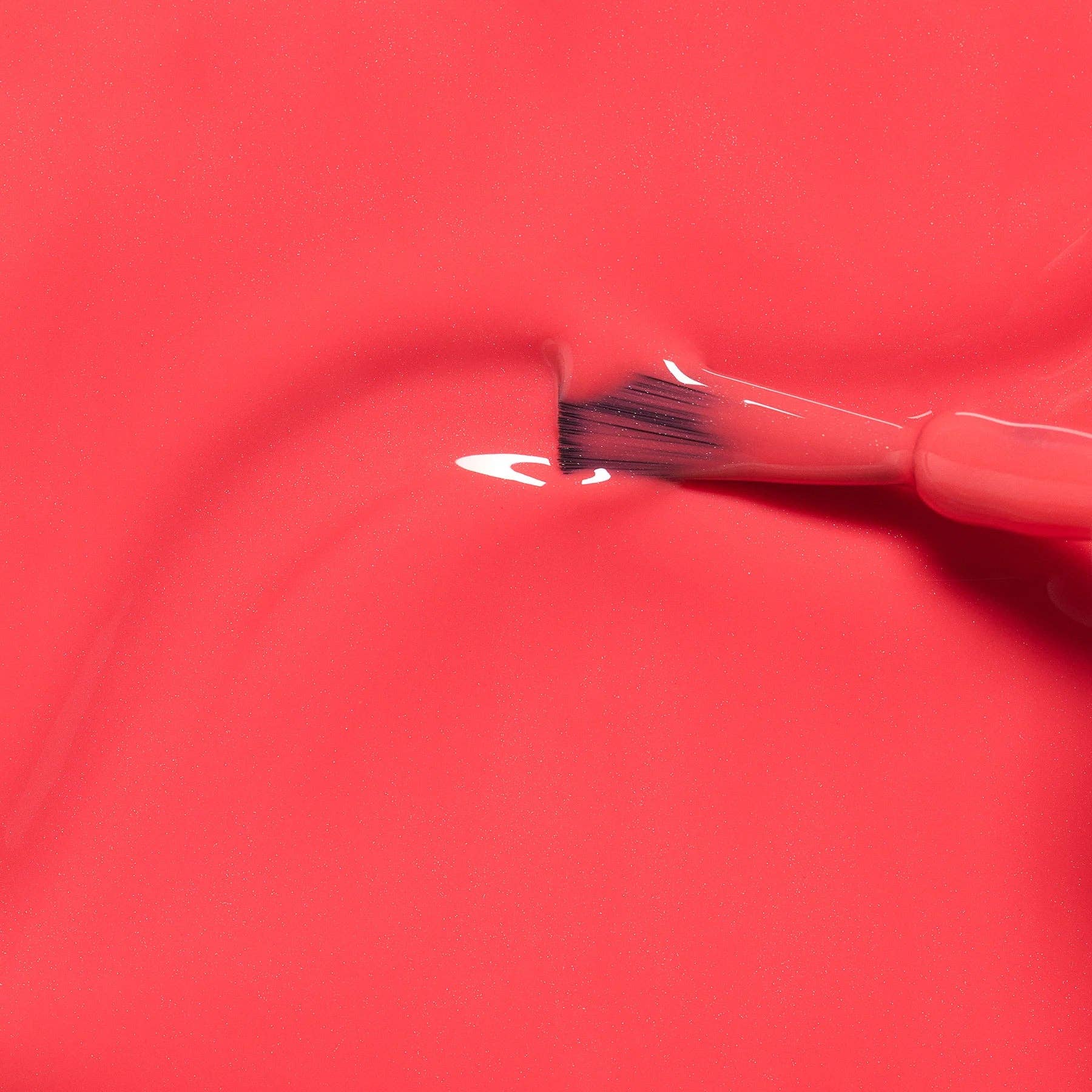 Brush applying white paint to a red surface