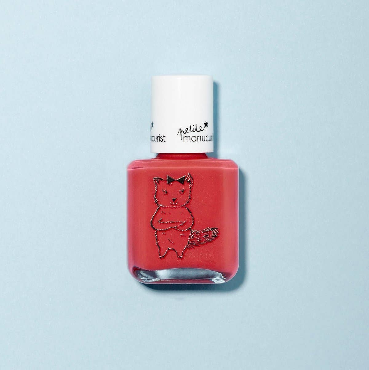 Red nail polish bottle with a white cap on a light blue background
