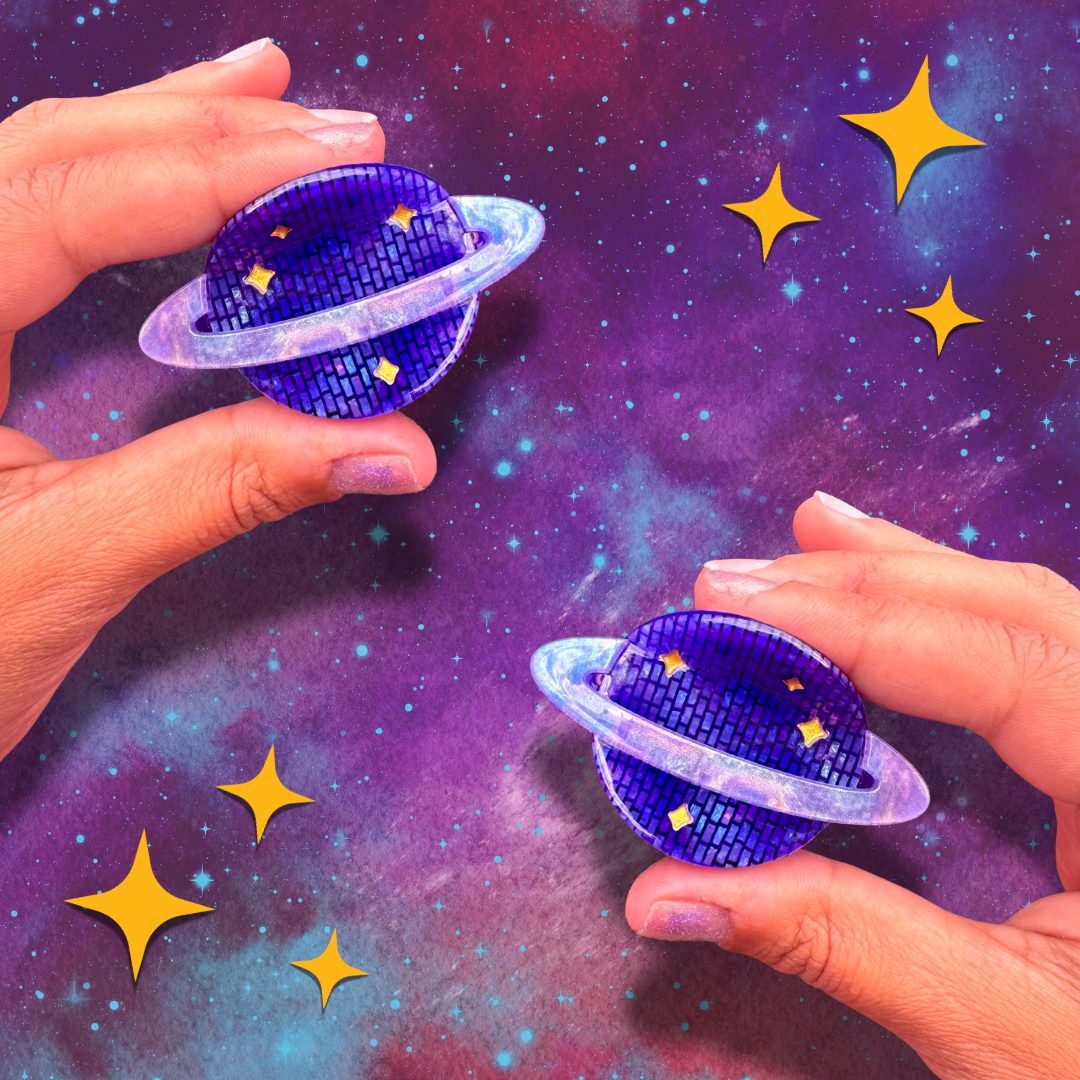 Two hands holding blue planet-shaped objects against a starry space background