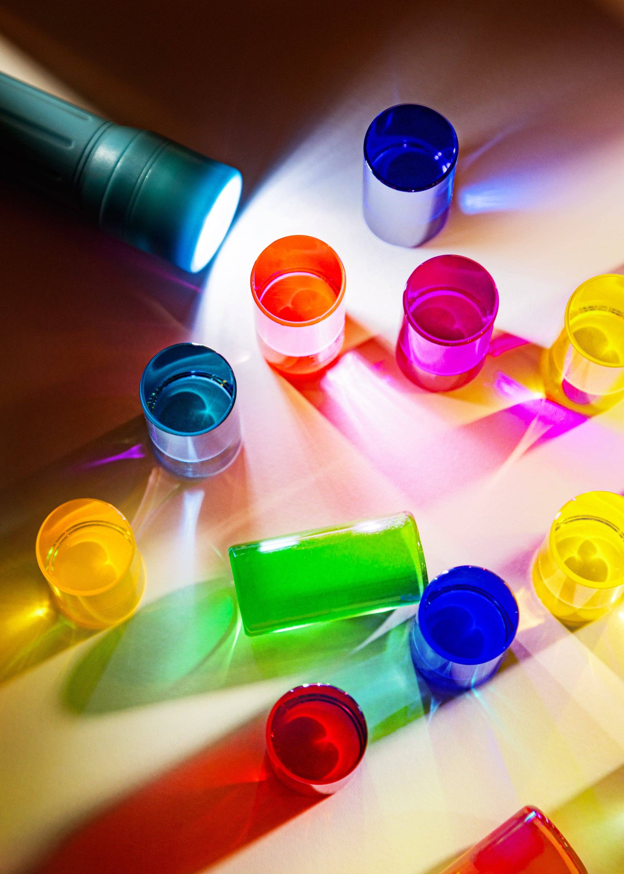 Colorful plastic cups on a reflective surface with light effects