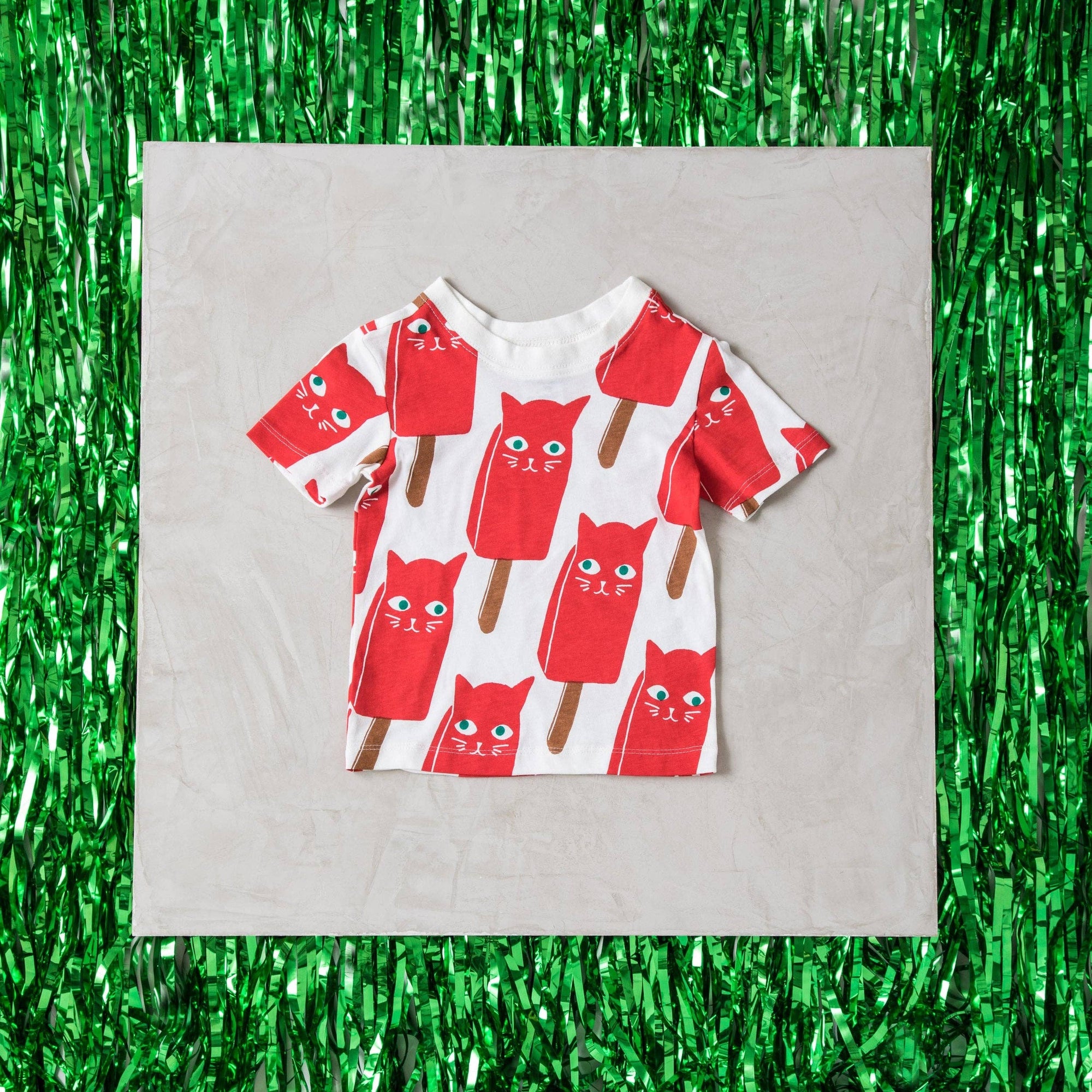 Children's t-shirt with red and brown cat design on a white background