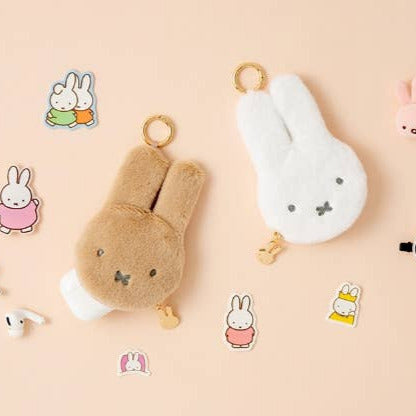 Plush keychain and stickers of a rabbit character on a beige background