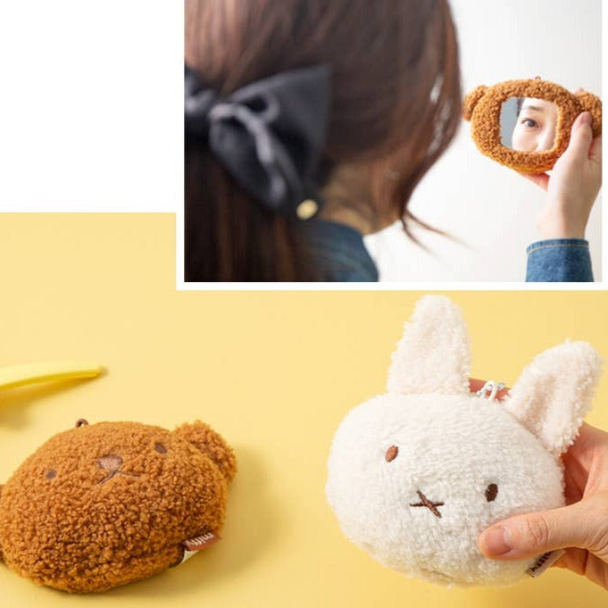Two plush toys, one brown and one white with bunny ears, on a yellow background.