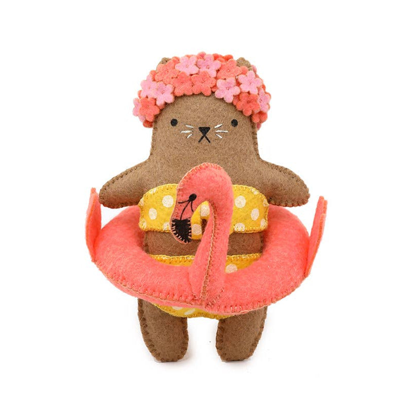 Stuffed animal toy resembling a bear in a swimsuit with a pink flamingo float and flower crown on a white background