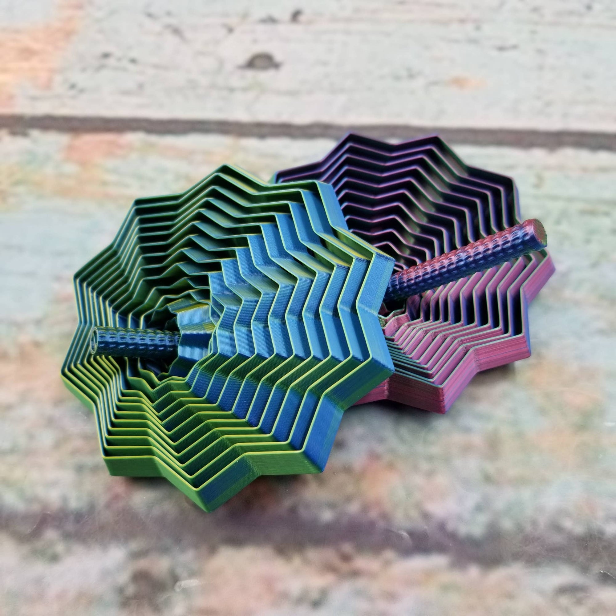Colorful geometric coasters stacked on a textured surface
