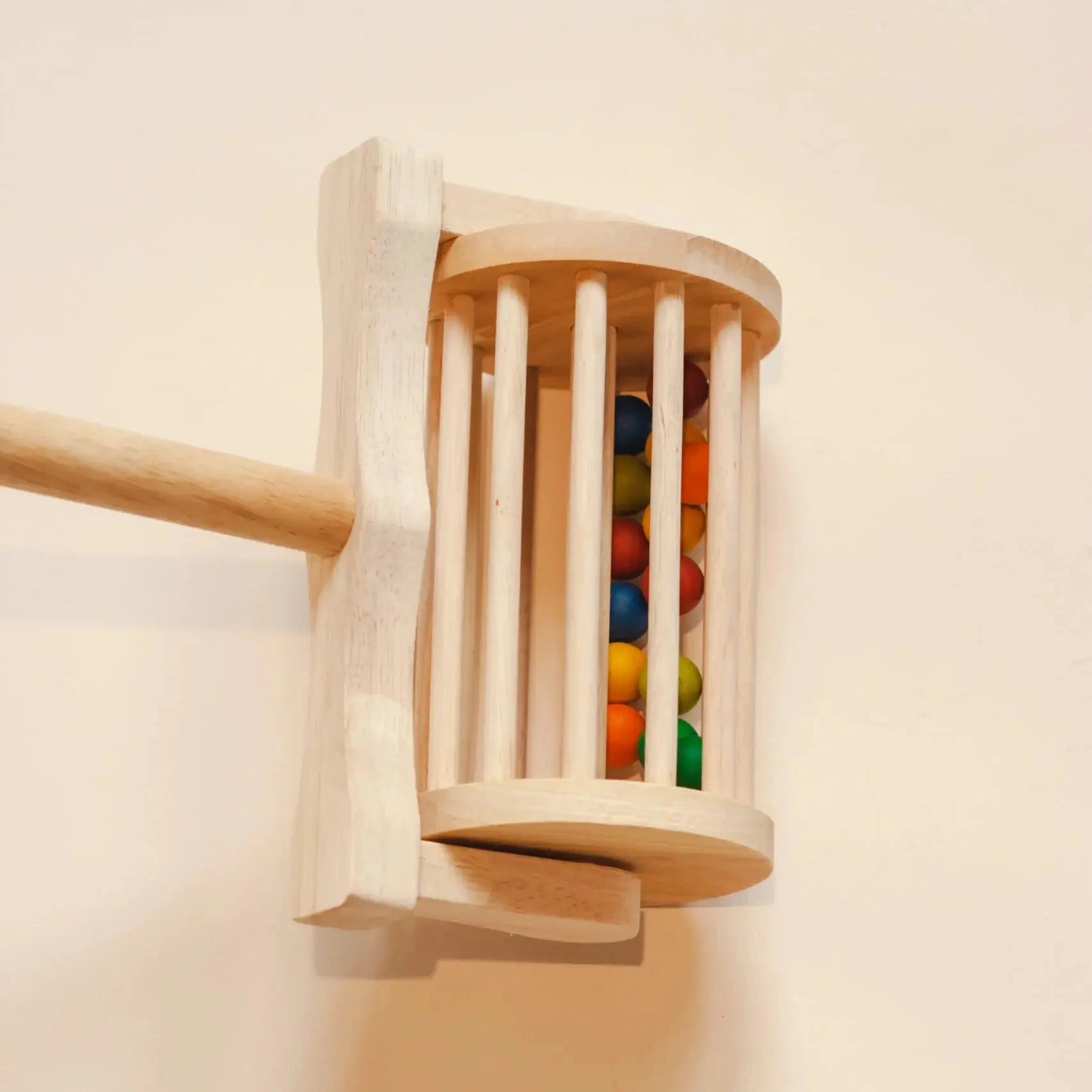Wooden toy with colorful beads inside on a light background