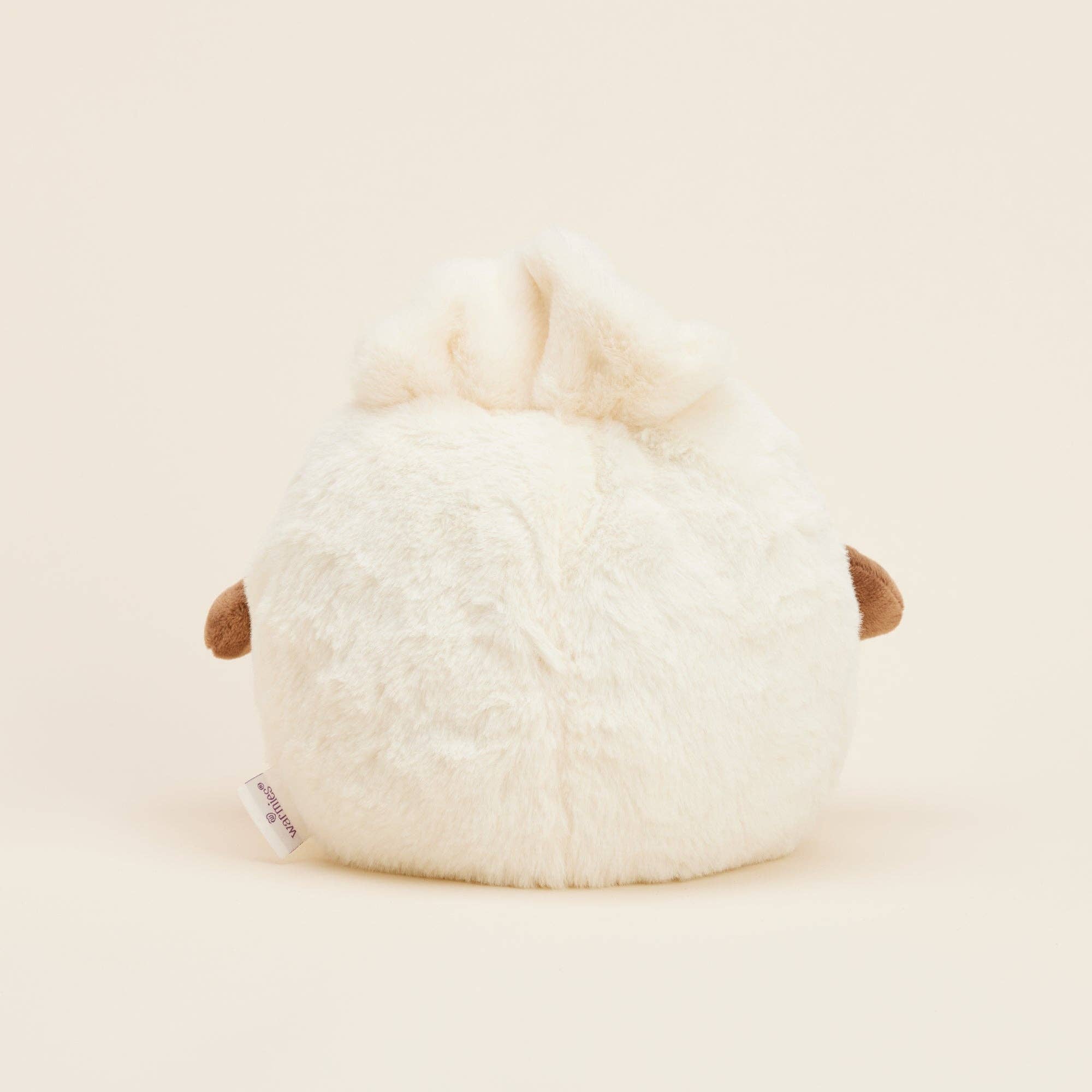 Close-up of a plush toy resembling a dumpling on a light beige background