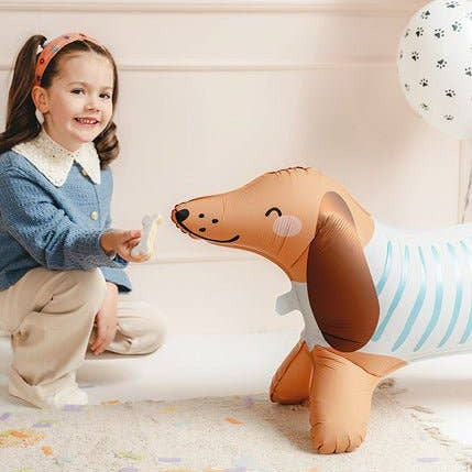 Child playing with an inflatable dog toy on a carpeted floor.