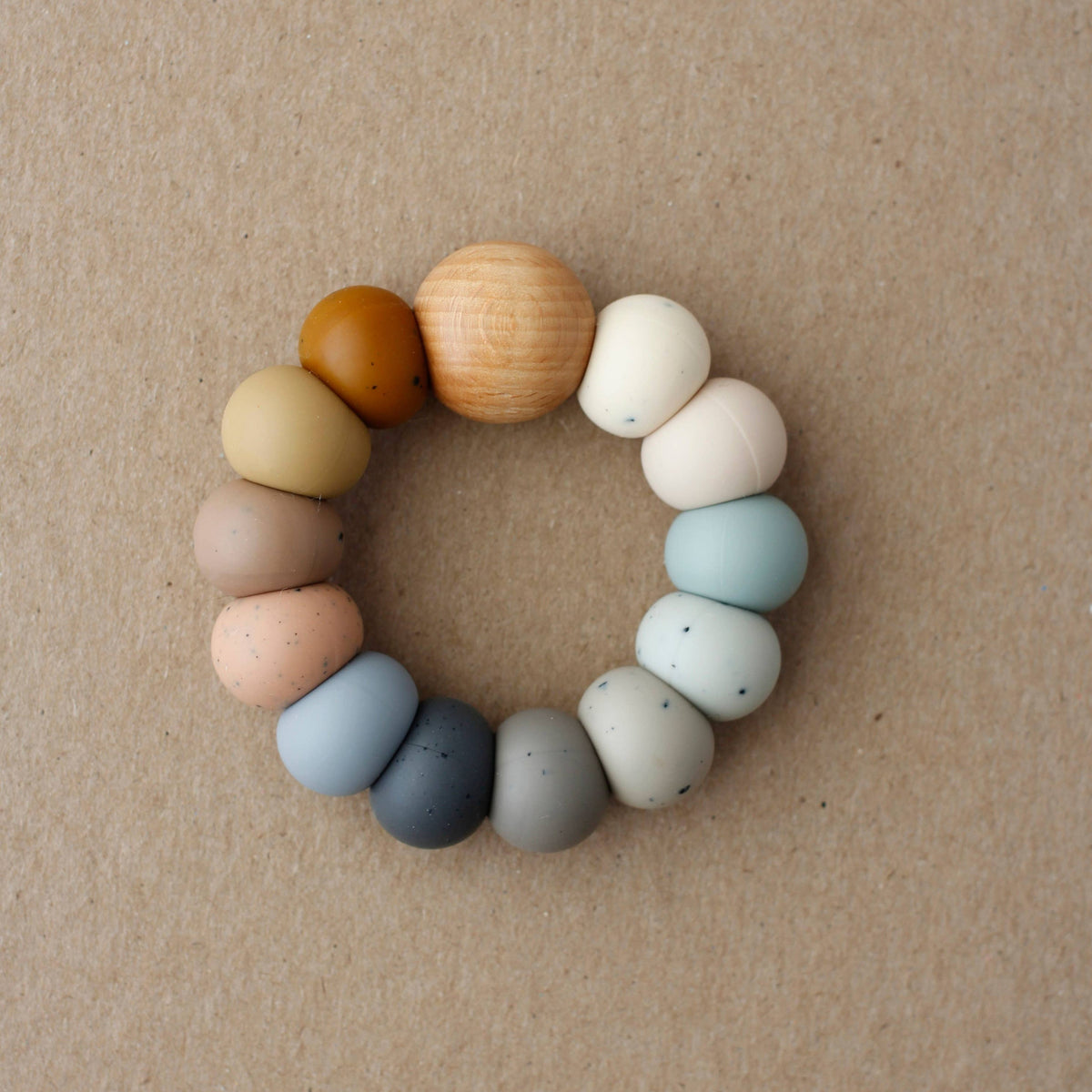 Colorful baby teething ring on a beige background