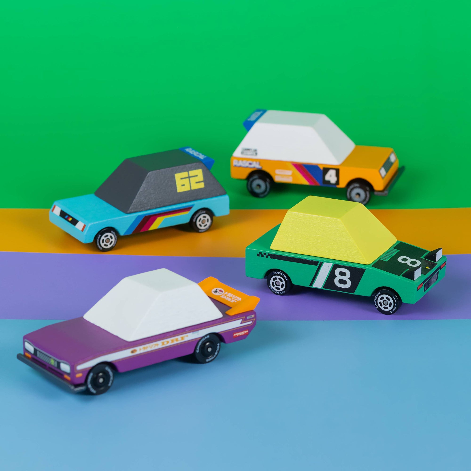 Four colorful toy cars on a green, orange, and blue gradient background