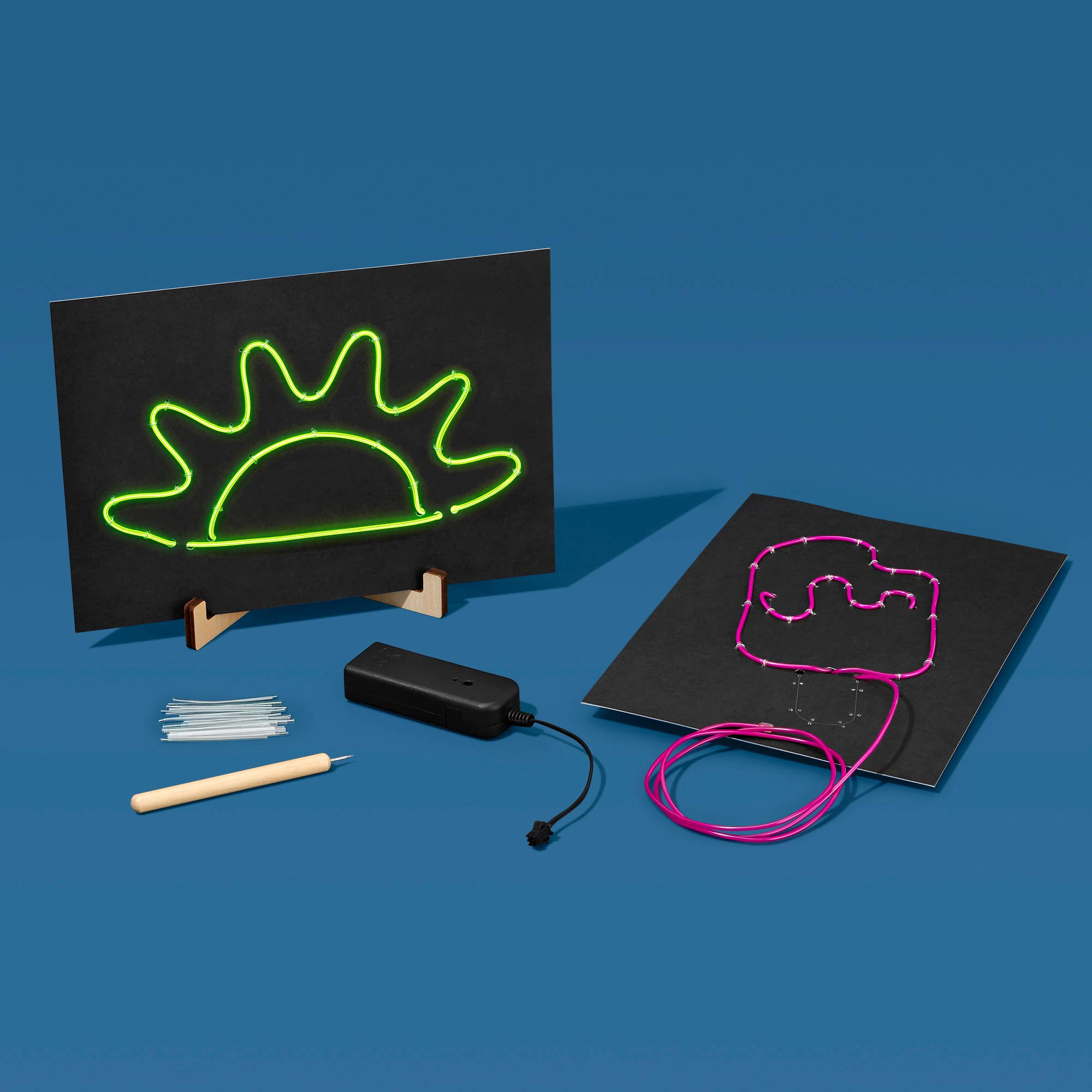 Neon art kit with blackboards, neon wires, and tools on a blue background