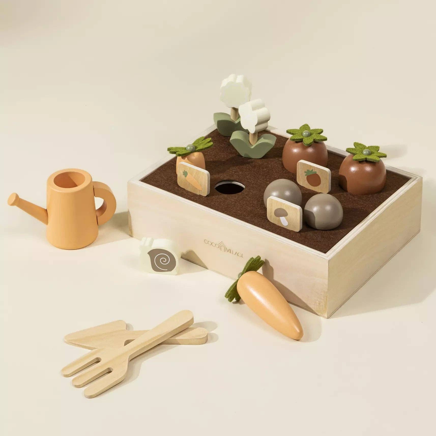 Children's playset with wooden tools, plants, and a watering can on a light background