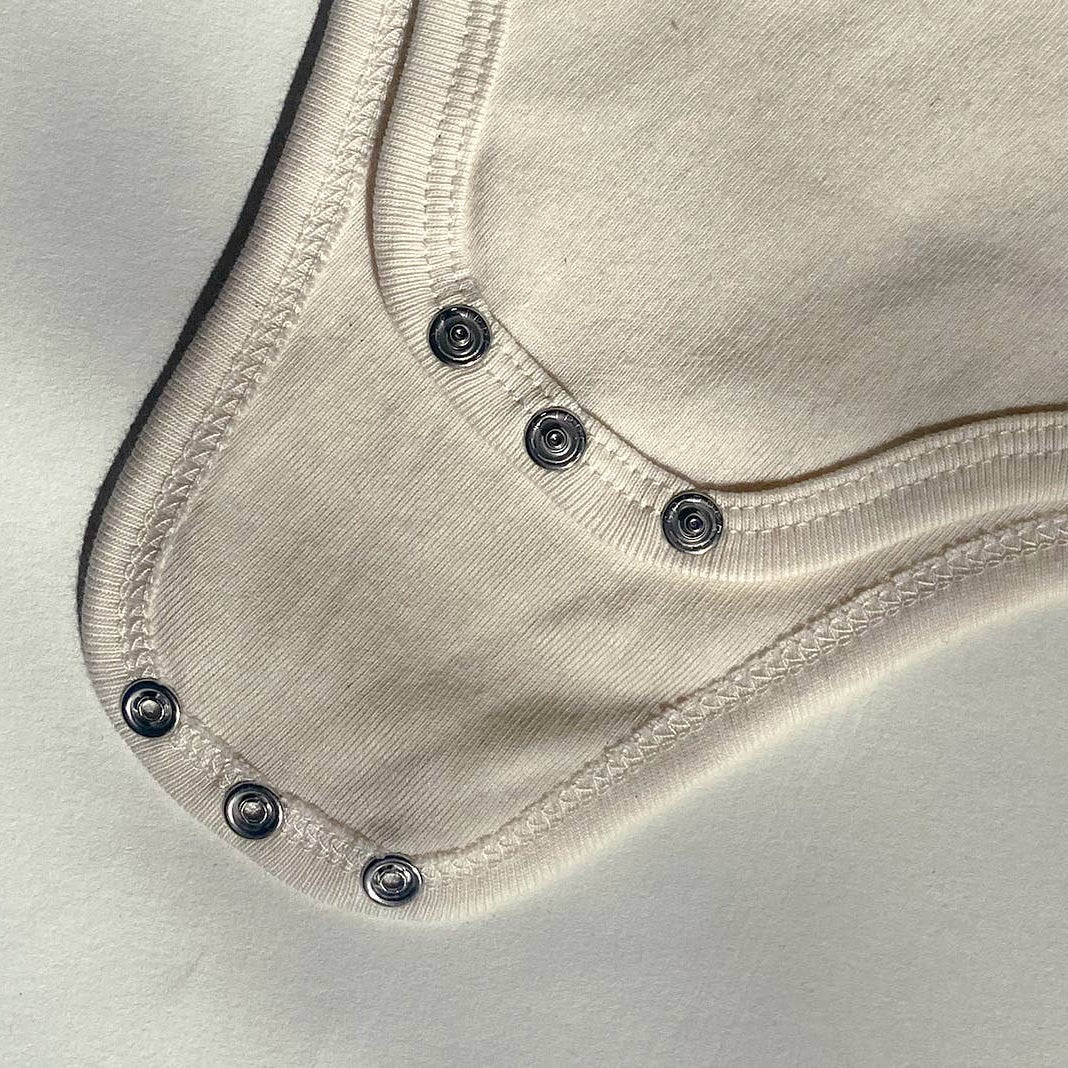 Close-up of a beige fabric with button details on a light gray background