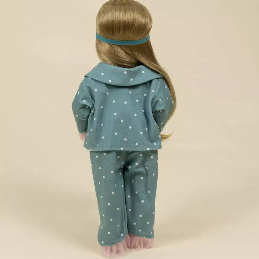 doll wearing a teal outfit with white polka dots on a beige background