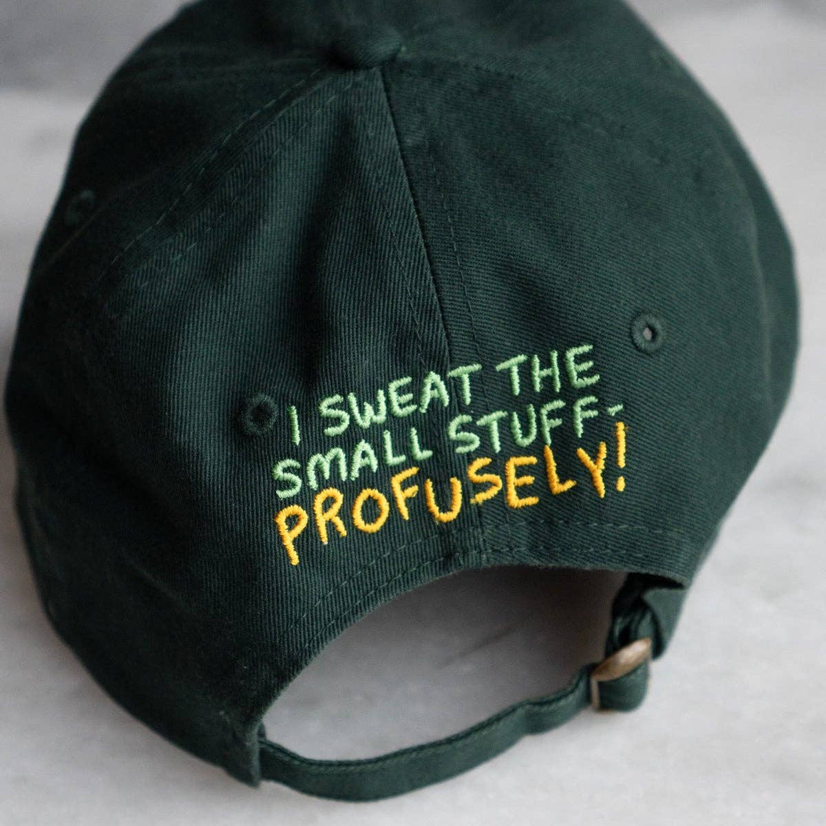 Green cap with humorous text on a gray background