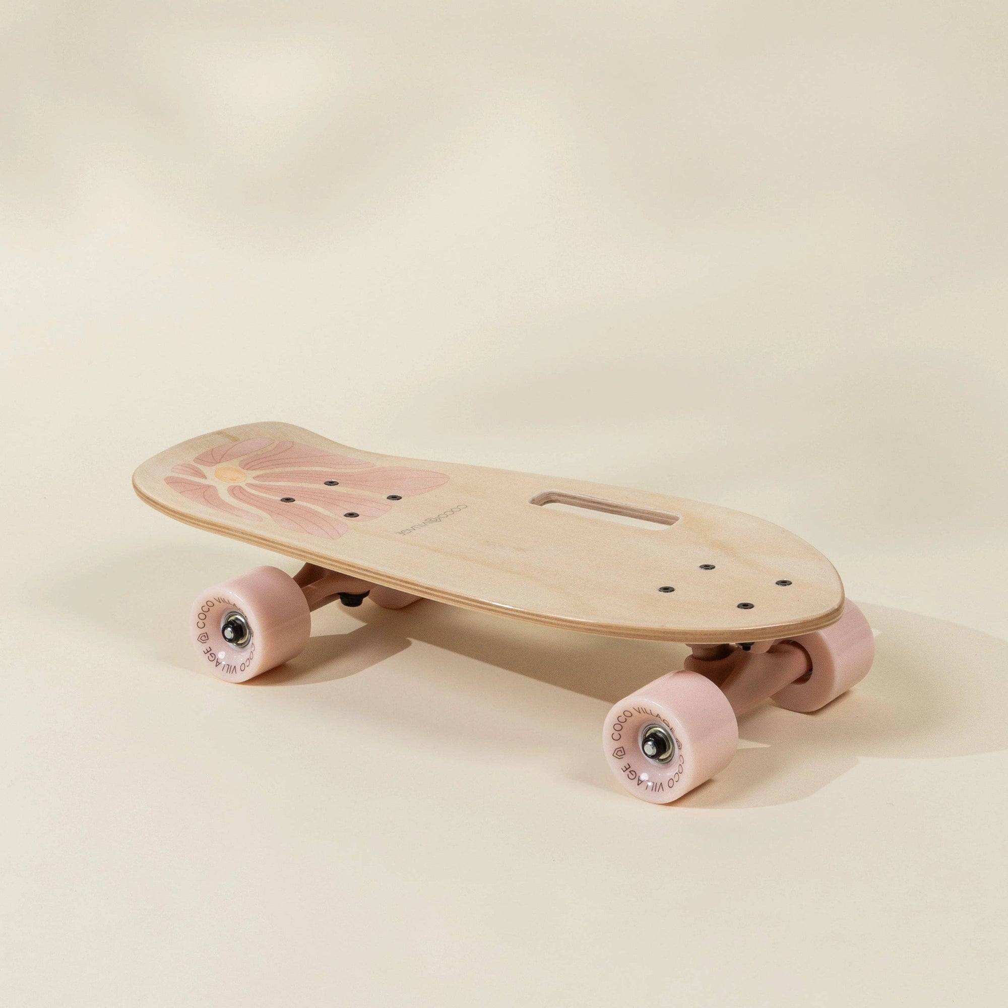 Pink skateboard with wooden deck on a beige background