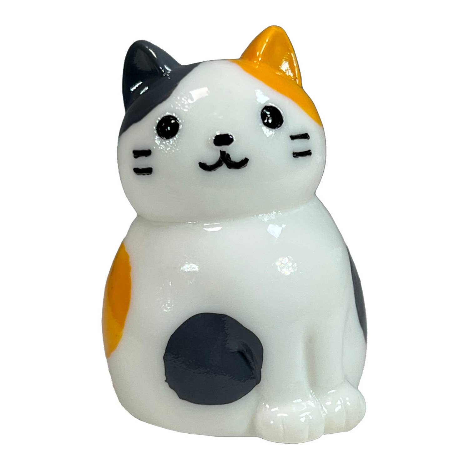Cat-shaped figurine with black, orange, and white colors on a white background