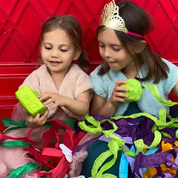 Two children playing with colorful toys against a red background