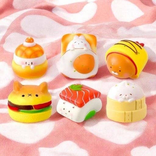 Set of cute, cartoon-like food-shaped items on a pink blanket with cloud pattern