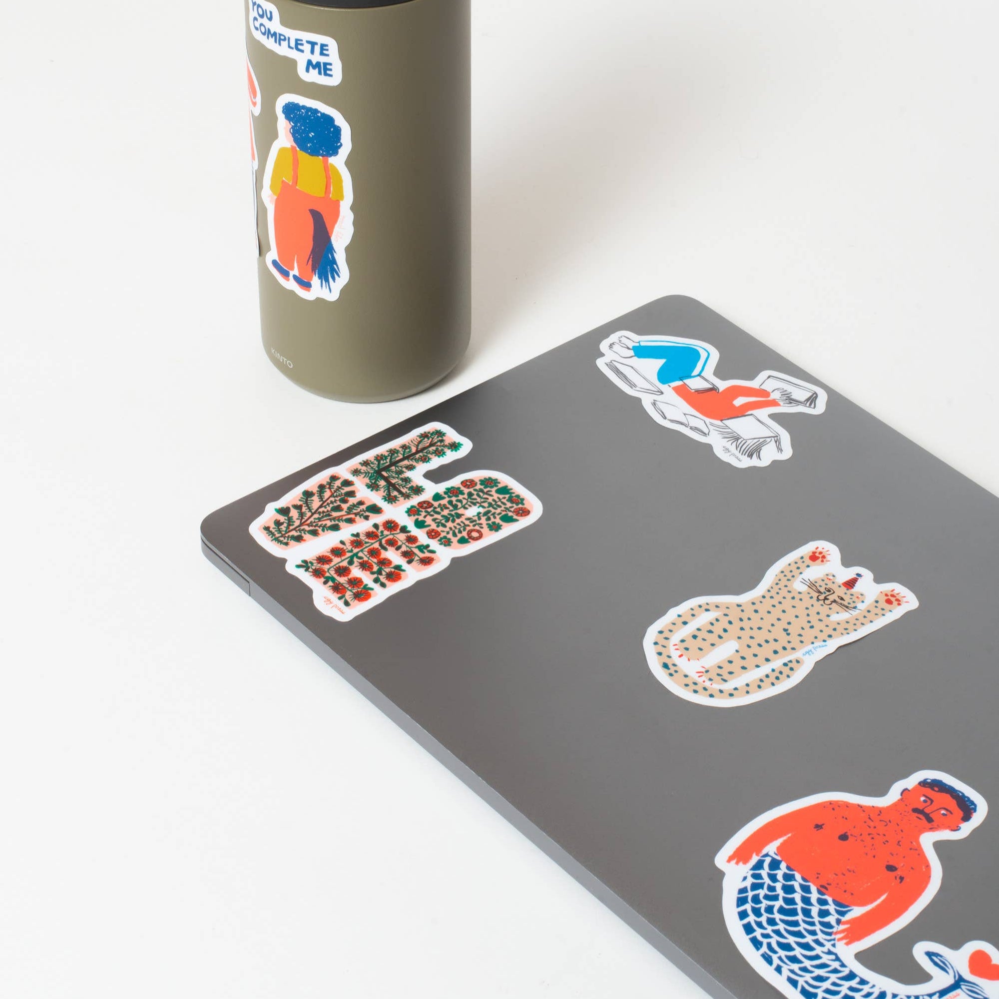 Gray computer with colorful stickers on a white background