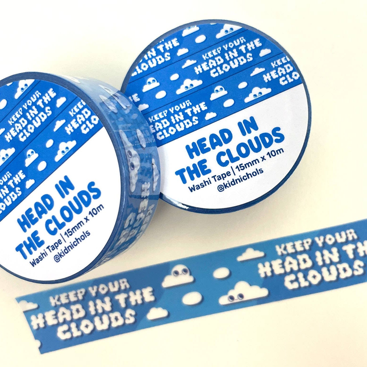 Two rolls of washi tape with 'Head in the Clouds' design on a white background