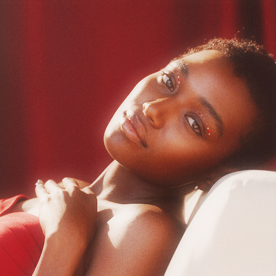 Person lying on a white surface with a red background
