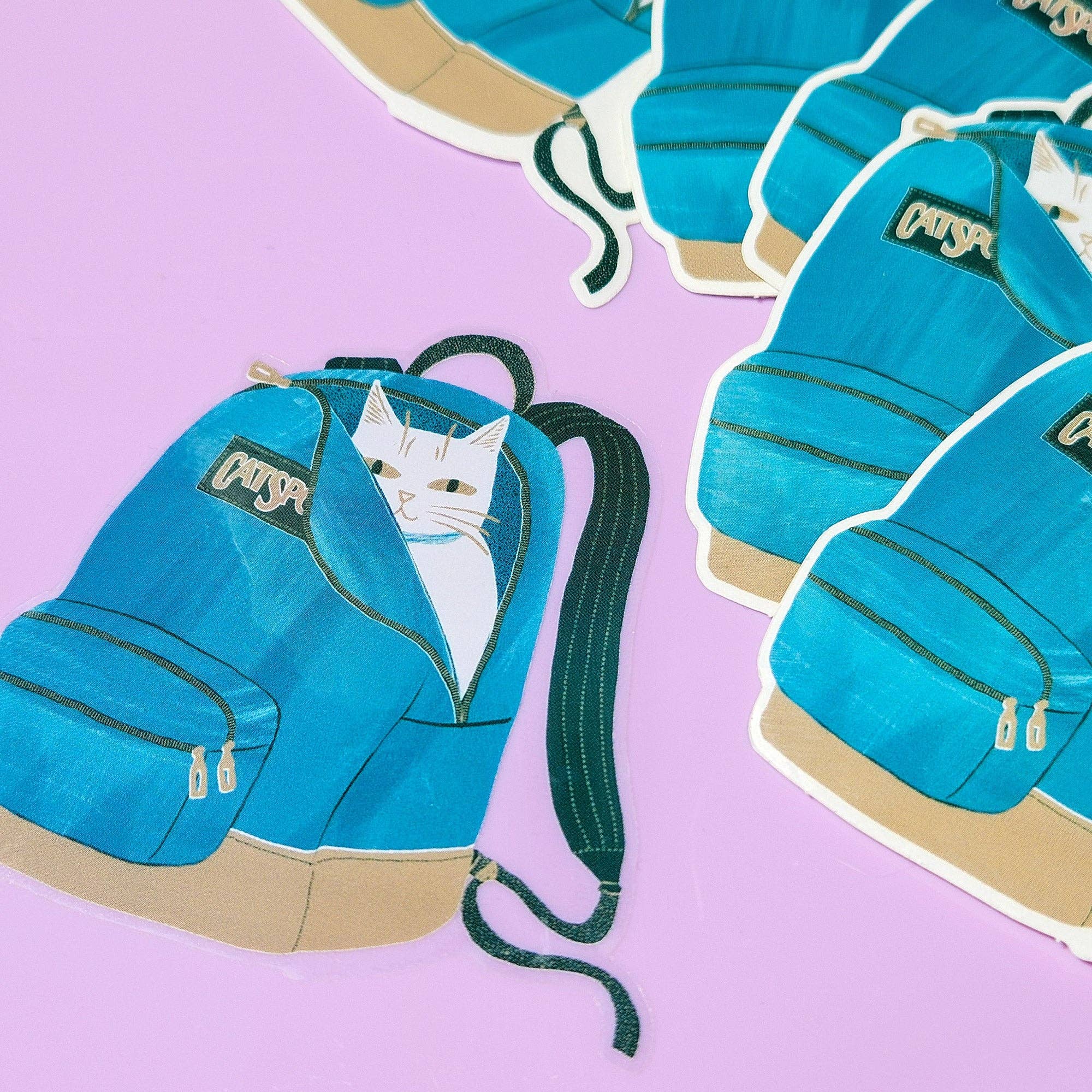 Illustration of a blue backpack with a cat peeking out on a pink background
