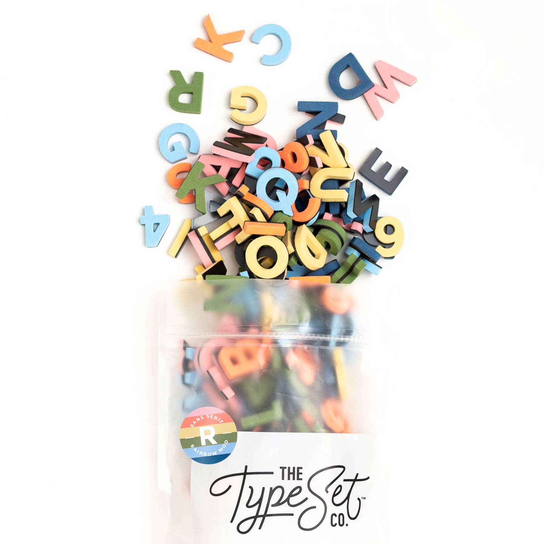 Colorful wooden letters spilling out of a clear container with 'The Type Set Co.' branding.