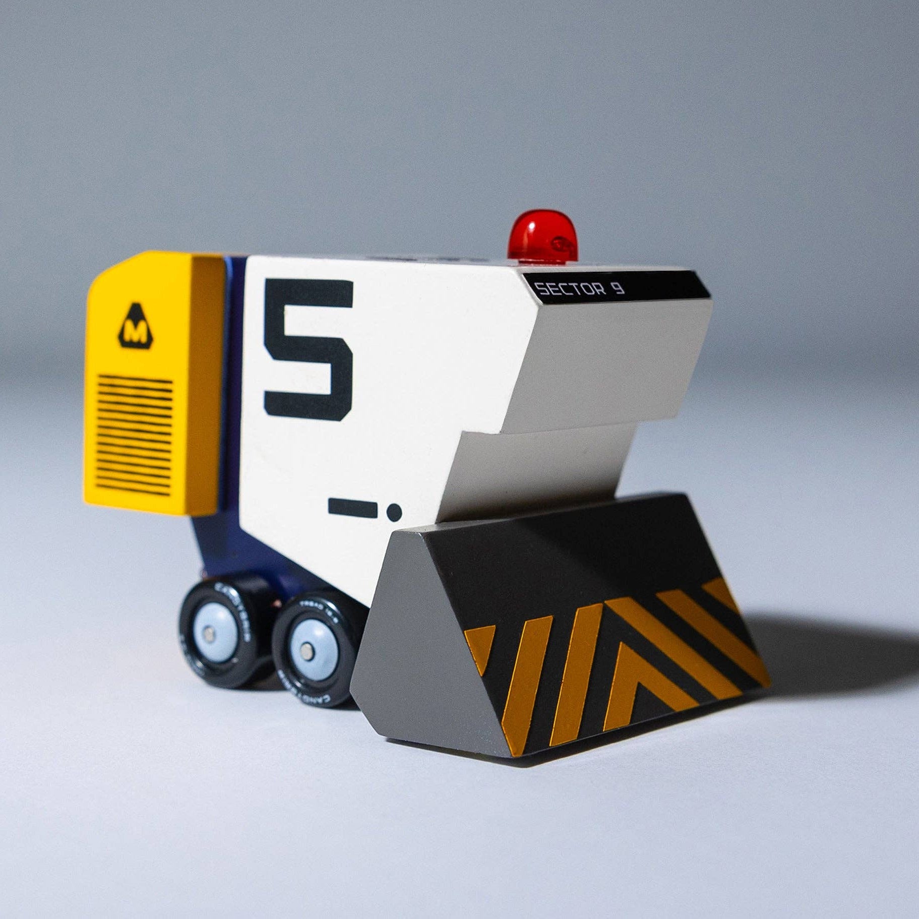 Toy bulldozer with number 5 on a gray background