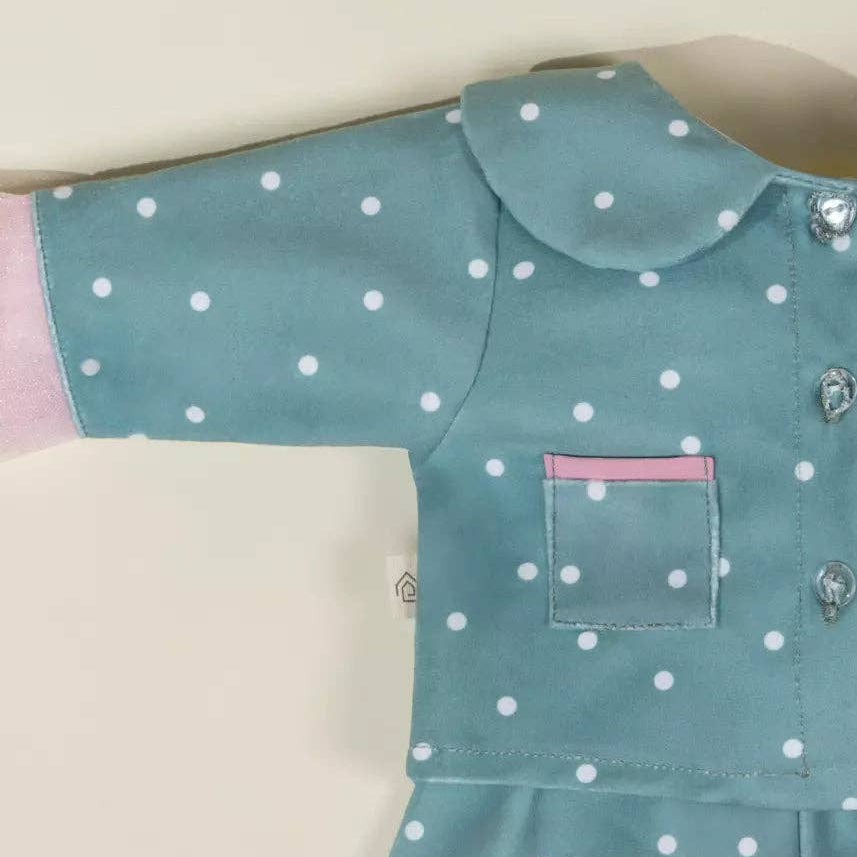 Teal shirt with white polka dots on a beige background