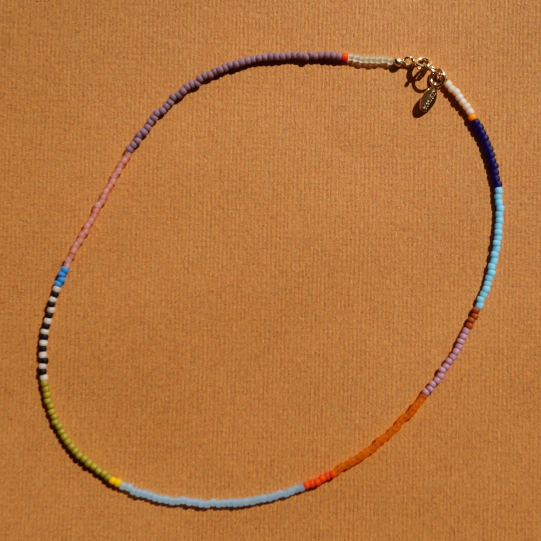 Colorful beaded necklace on a brown background