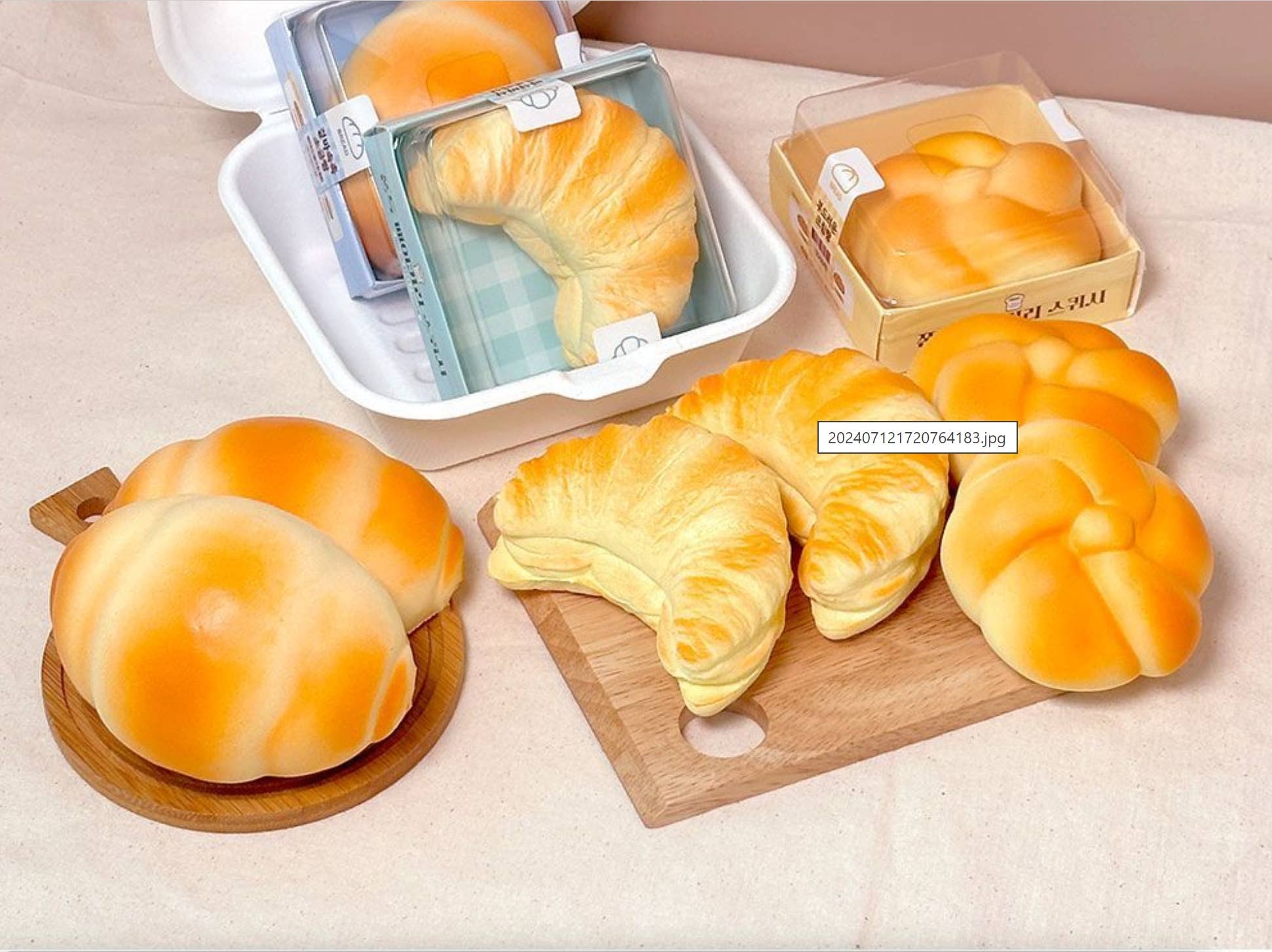 Various bread-shaped products on a wooden board and beige surface