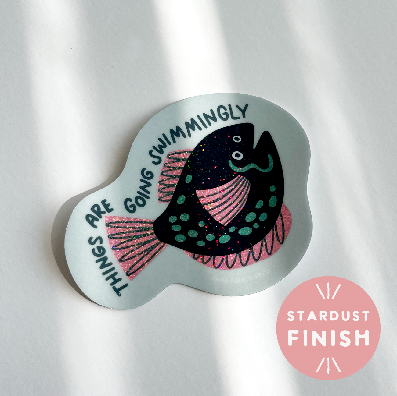 Decorative sticker with a fish design and text on a light background