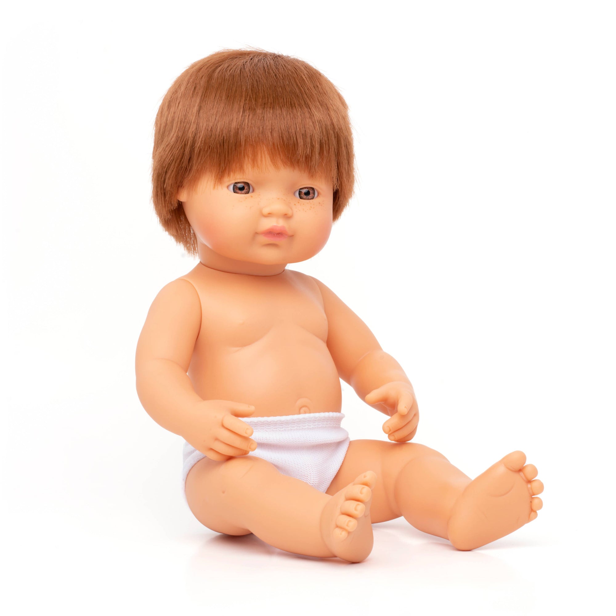 Baby doll with brown hair and a white diaper on a white background