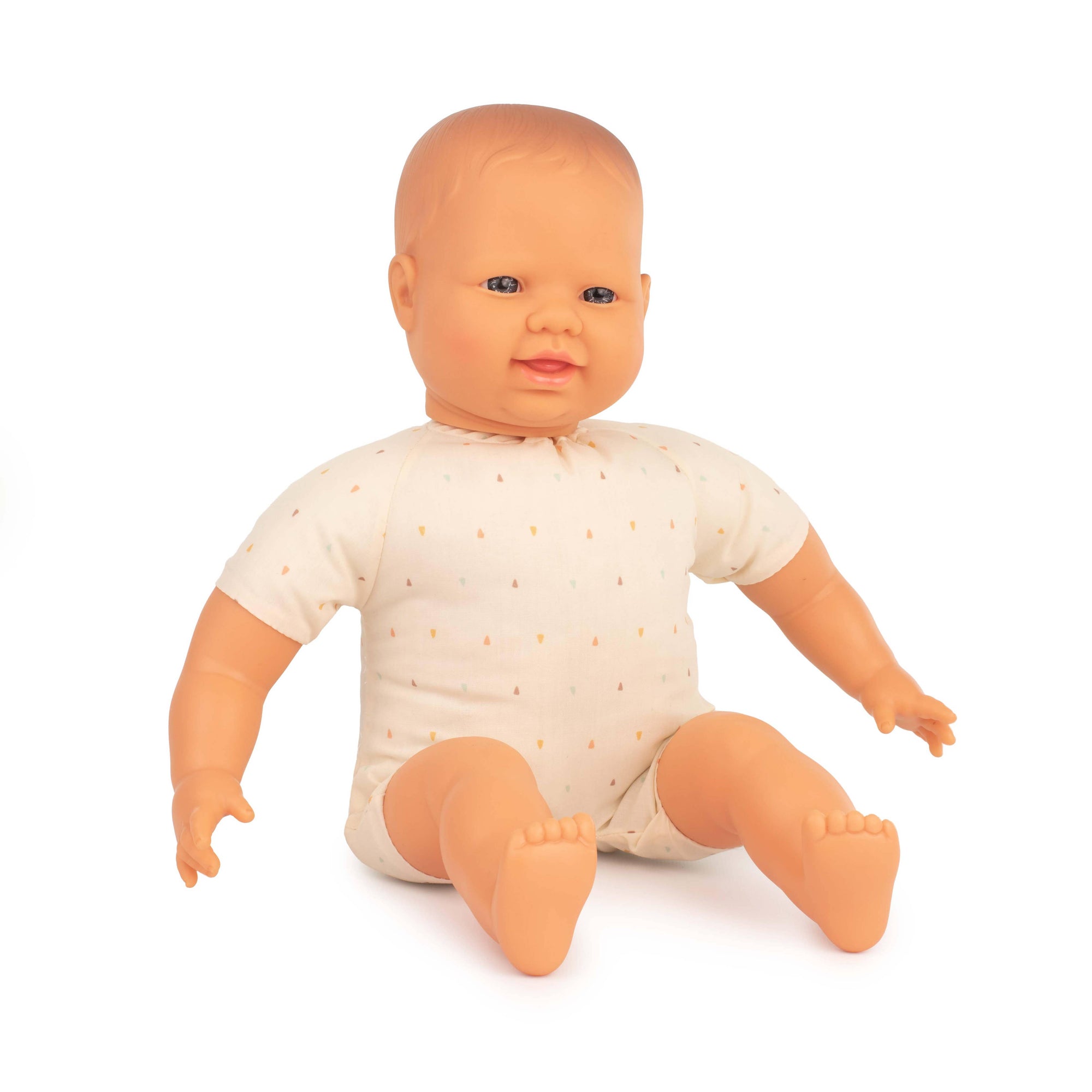 Baby doll wearing a white onesie with small patterns on a white background