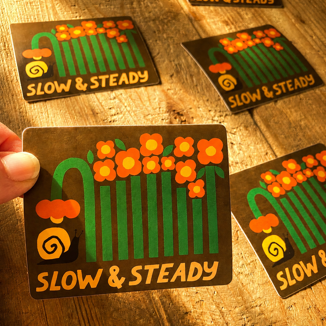 Stickers with 'Slow & Steady' design on a wooden surface