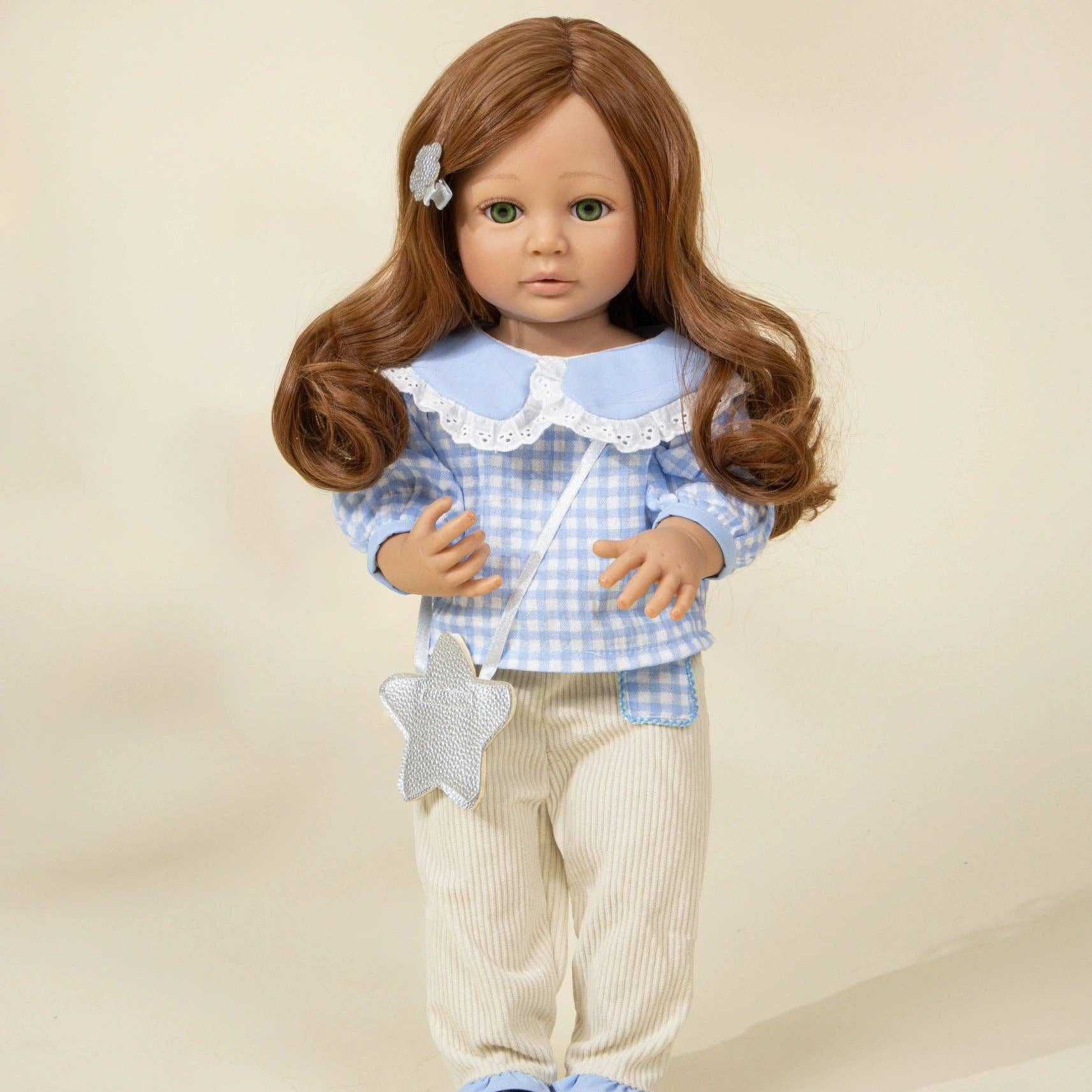 Doll with long brown hair wearing a blue checkered shirt and beige pants on a beige background