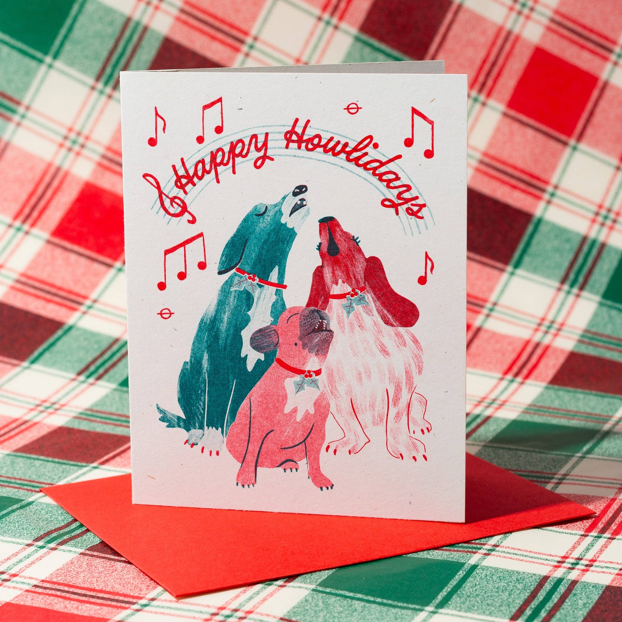 Greeting card with dogs and 'Happy Howlidays' text on a plaid background
