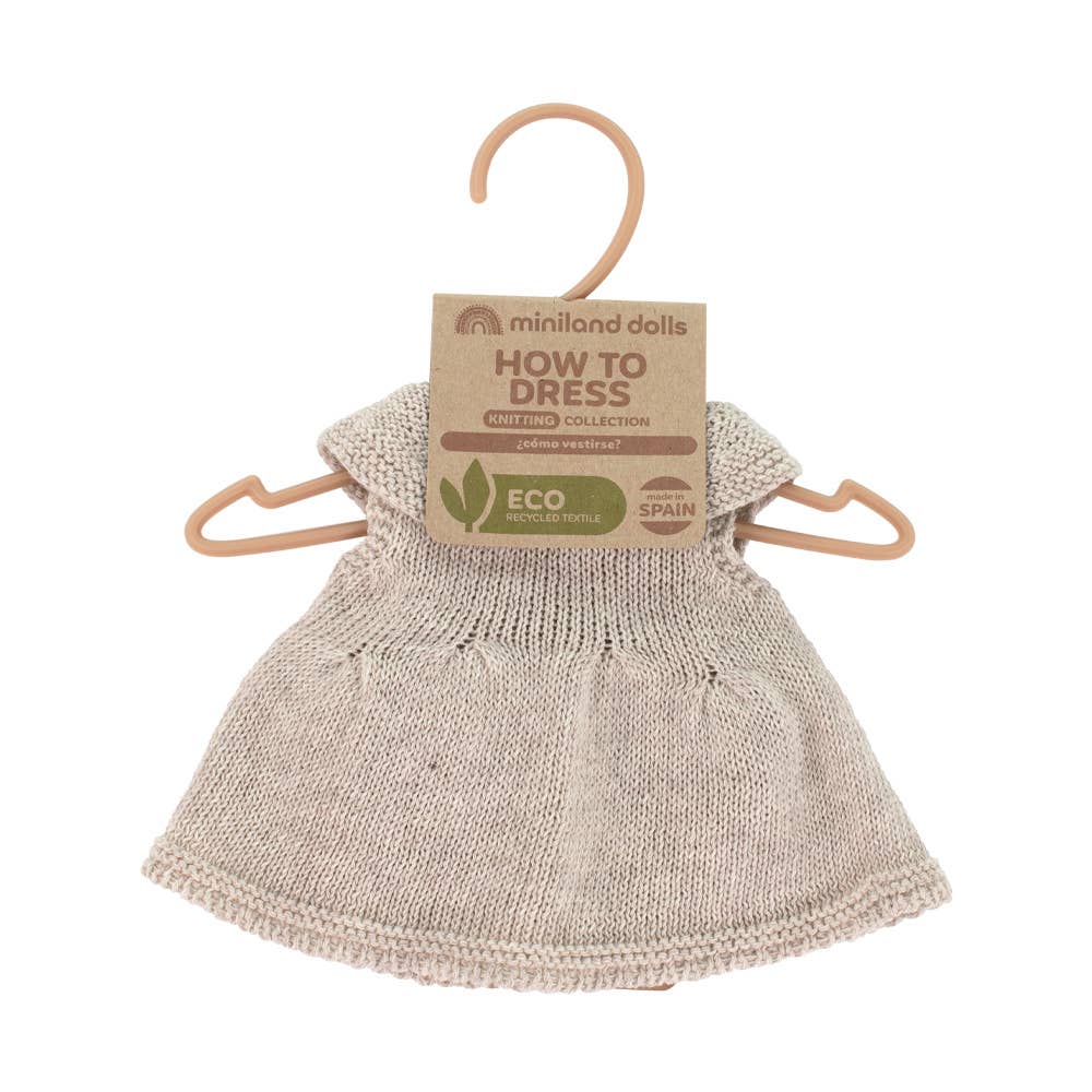 Knitted doll on a hanger with 'How to Dress' label on a white background