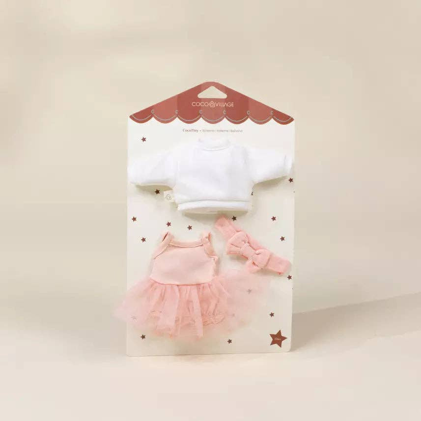 A doll clothing set in its original retail packaging, featuring a white long-sleeve top, a pink tutu dress, and a pink bow headband on a cream-colored card.