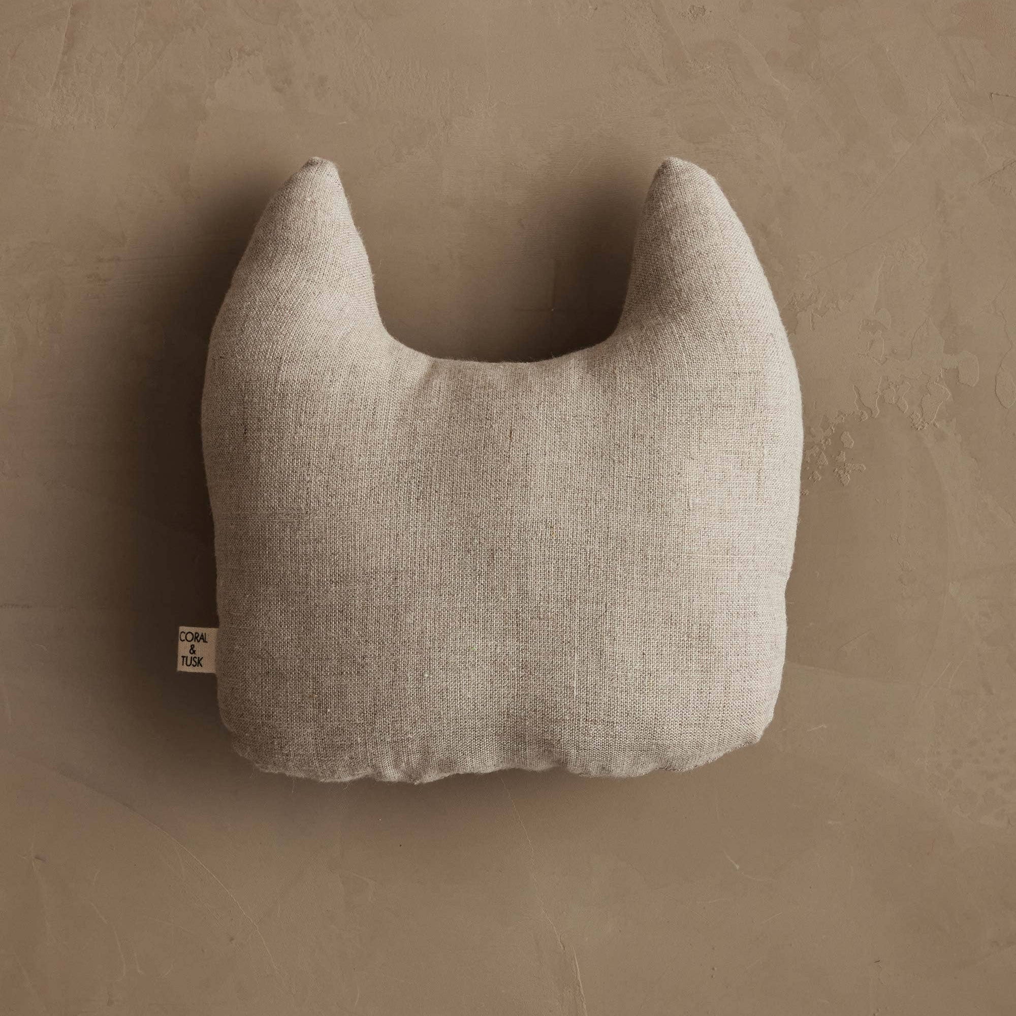 Textured beige neck pillow on a brown background