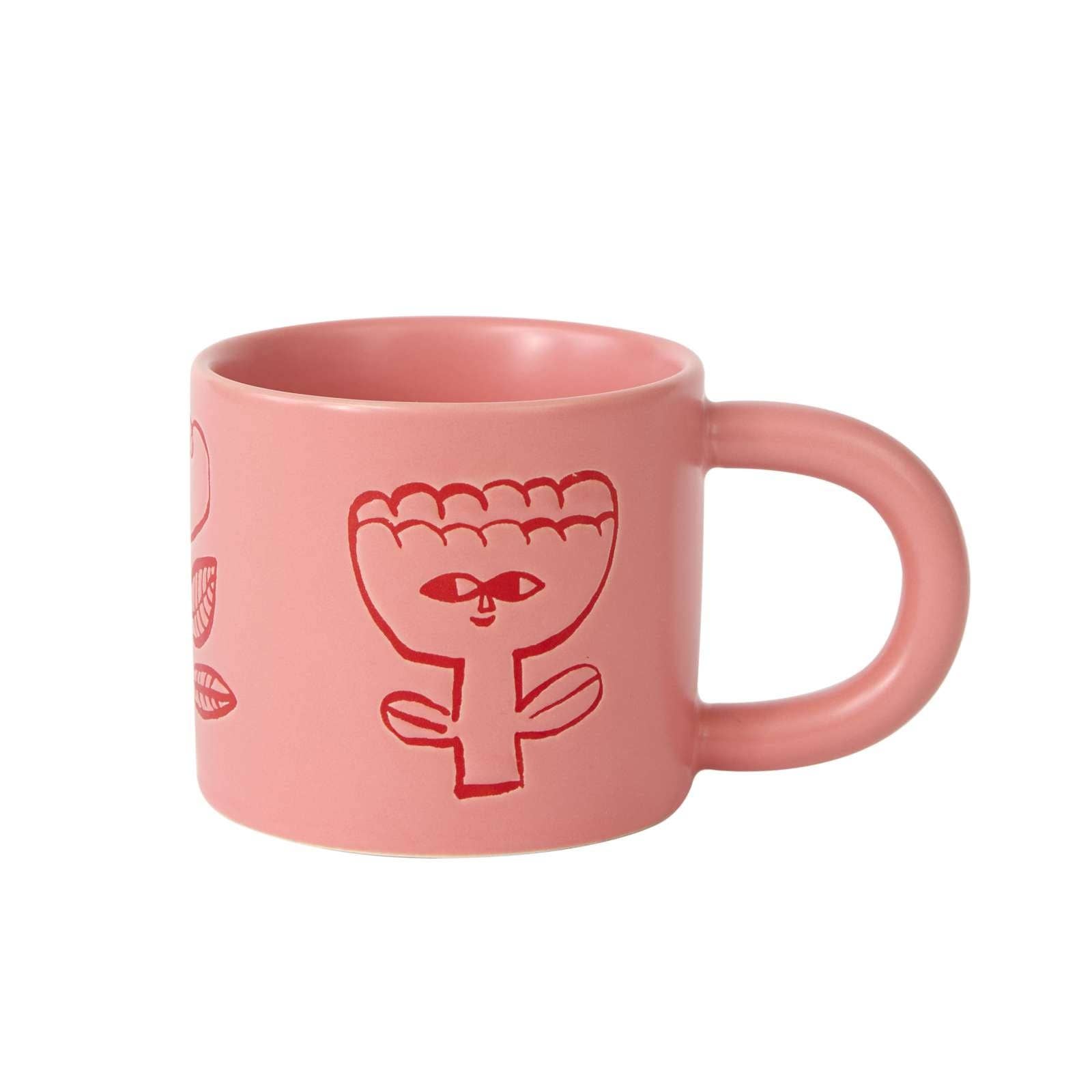 Pink mug with red abstract design on a white background