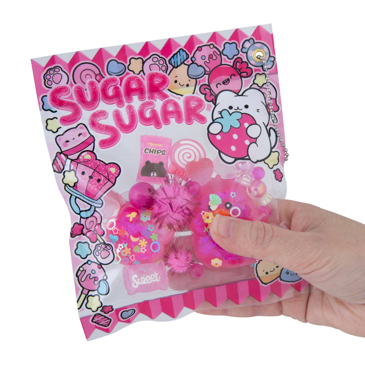 Hand holding a 'Sugar Sugar' toy package with cartoon characters on a white background