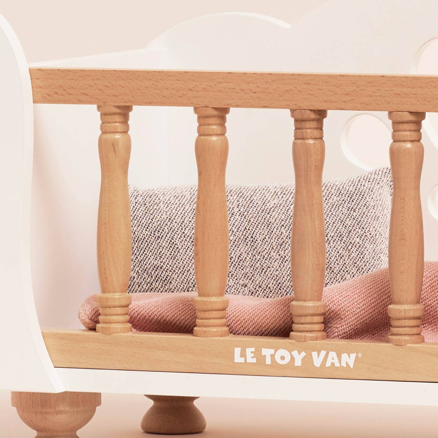 Wooden toy bed with pink mattress and 'Le Toy Van' branding on a white background