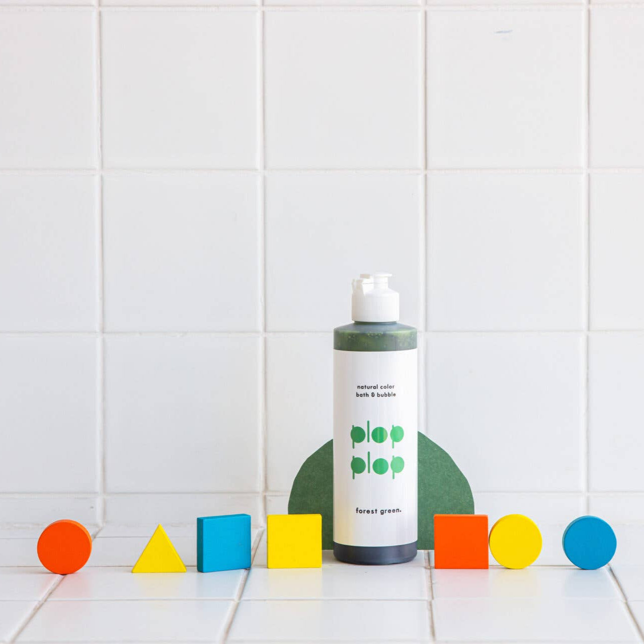 Bottle of soap with colorful geometric shapes on a tiled floor